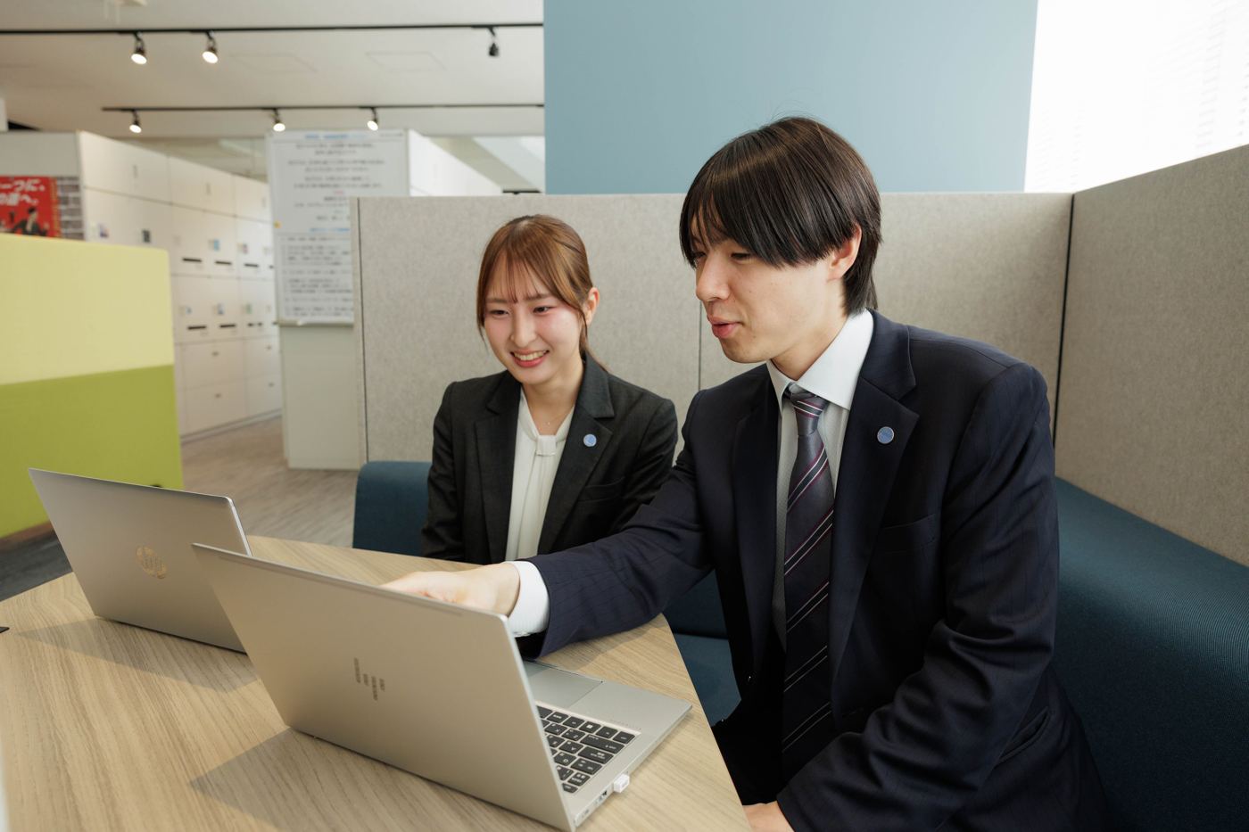先輩社員と一緒にPCを見る新入社員